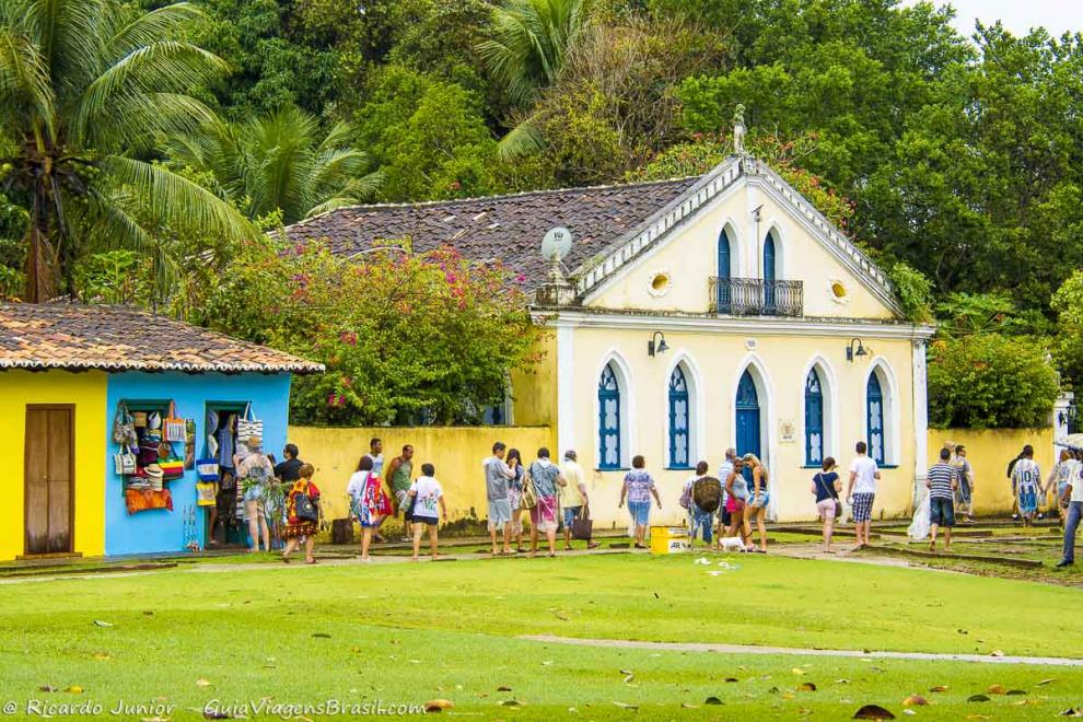 Imagem de turistas passando em frente as lojinhas da Aldeia Indígena.